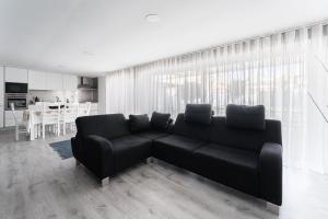 a living room with a black couch and a kitchen at GuestReady - Amazing holiday home near the beach in Vila Nova de Gaia