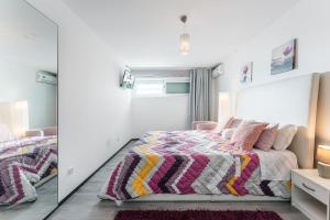 a bedroom with a bed and a mirror at GuestReady - Amazing holiday home near the beach in Vila Nova de Gaia