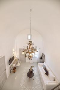 a living room with a couch and a chandelier at Coco-Mat Hotel Santorini in Akrotiri