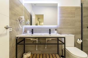 uma casa de banho com um lavatório, um WC e um espelho. em Allo Apartments Arroyo Catedral em Jerez de la Frontera