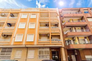 un edificio anaranjado con balcones en el lateral. en ALEGRIA ID93, en Torrevieja