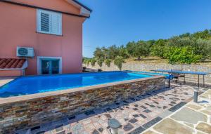 a swimming pool in front of a house at Nice Apartment In Koper With Outdoor Swimming Pool, 3 Bedrooms And Wifi in Koper