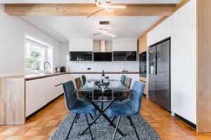 a kitchen with a glass table and blue chairs at GuestReady - Urban Retreat in Gaia in Vila Nova de Gaia