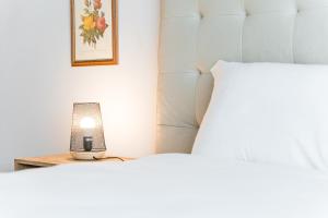 a lamp sitting on a table between two beds at GuestReady - Modern apt near Matosinhos Beach in Matosinhos