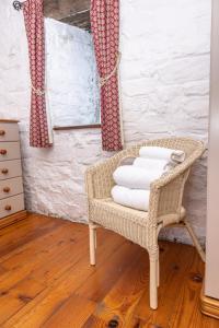 a wicker chair with towels on it in a room at The Coach House in Bridgend