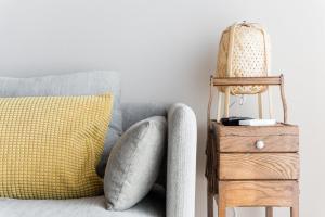 Sofá gris con almohada amarilla y mesa auxiliar de madera en GuestReady - Fantastic apt overlooking Douro river, en Oporto