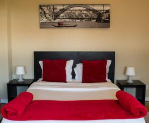 - une chambre avec un grand lit et des oreillers rouges dans l'établissement GuestReady - Cozy Boavista Studio 1B, à Porto