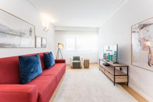 sala de estar con sofá rojo y mesa en GuestReady - Geometric Dawn in Vila do Conde, en Vila do Conde
