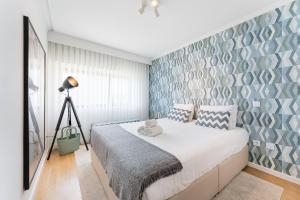 Un dormitorio con una cama con una pared de acento azul en GuestReady - Geometric Dawn in Vila do Conde, en Vila do Conde