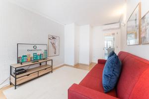 a living room with a red couch and a tv at GuestReady - Geometric Dawn in Vila do Conde in Vila do Conde