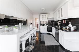 una cocina con armarios blancos y encimeras blancas en GuestReady - Geometric Dawn in Vila do Conde, en Vila do Conde