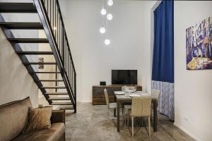 ein Wohnzimmer mit einem Tisch und einer Treppe in der Unterkunft Zecca Contemporary Loft by Wonderful Italy in Genua