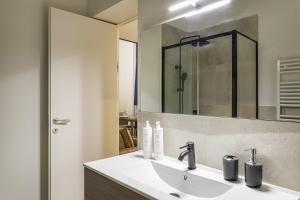 ein Bad mit einem Waschbecken und einem Spiegel in der Unterkunft Zecca Contemporary Loft by Wonderful Italy in Genua