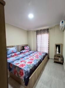 ein Schlafzimmer mit einem Bett mit blauer Decke und einem Kamin in der Unterkunft LASIRENA PALM BEACH RESORT -FAMILY in Ain Suchna