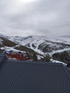 a view of a snowy mountain from a roof at BUENAVISTA LUXURY in Sierra Nevada