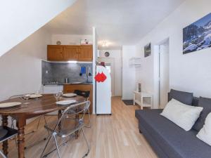 cocina y sala de estar con mesa y nevera. en Appartement T2 à Cauterets, proche télécabine avec parking et local ski - FR-1-401-198, en Cauterets