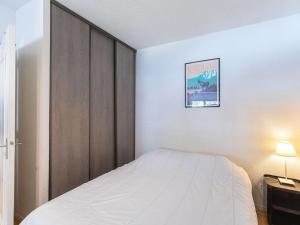 1 dormitorio con cama y armario de madera en Appartement T2 à Cauterets, proche télécabine avec parking et local ski - FR-1-401-198, en Cauterets