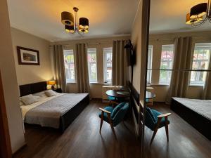 une chambre avec deux lits et une table et des chaises dans l'établissement Apartamenty Classico na deptaku, à Karpacz