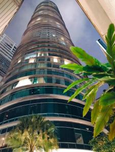 un edificio alto con palmeras delante en Vortex suites klcc by Rahat, en Kuala Lumpur
