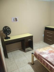 um quarto com uma secretária e uma cama num quarto em Residencial Barbosa - Apto 302 em Macaé