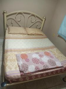 a bed with a metal frame with two pillows on it at Residencial Barbosa - Apto 302 in Macaé