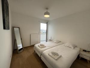 2 aparte bedden in een kamer met een spiegel bij View Point Imperial lake in Annecy