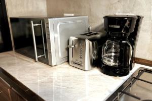 a kitchen counter with a coffee maker and a microwave at Tranquil refuge in Xalapa, 3BR 1BA apt for 6 in Xalapa