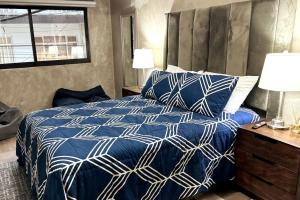 Schlafzimmer mit einem blauen und weißen Bett und einem Fenster in der Unterkunft Tranquil refuge in Xalapa, 3BR 1BA apt for 6 in Xalapa