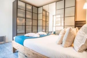 um quarto com uma cama grande e almofadas brancas em DAISY em Chamonix-Mont-Blanc