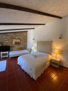 una camera con due letti e un muro di pietra di Rabacal Hotel Suite B&B with pool a Chanca