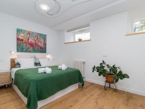 um quarto com uma cama com um cobertor verde em Espectacular apartamento en el Sardinero em Santander