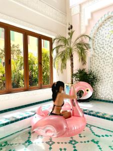 a girl in an inflatable pig in a swimming pool at Mellon OASIS Phu Quoc in Phu Quoc