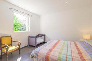 Un dormitorio con una cama y una silla y una ventana. en San Quilico - Maison climatisée piscine vue mer, en Aregno