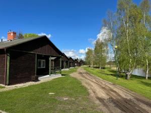 a dirt road next to a row of houses at Petrico Camp Resort in Krzywopłoty