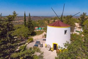 een kleine witte windmolen met een rood dak bij Quinta Molinum Ad Mare in Boliqueime