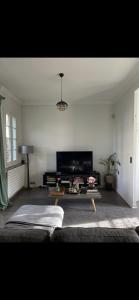 una sala de estar con un sofá y una mesa en Maison conviviale de caractère, en Colombes