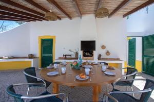 een eetkamer met een houten tafel en stoelen bij Quinta Molinum Ad Mare in Boliqueime