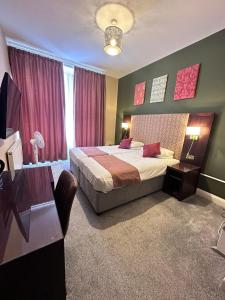 a bedroom with a bed and a table and a window at Acacia Hotel in London +48 photos