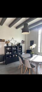 Un comedor con una mesa y sillas blancas. en Maison conviviale de caractère, en Colombes