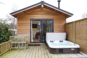 bañera en la cubierta de una casa en Braidhaugh Holiday Lodge and Glamping Park, en Crieff