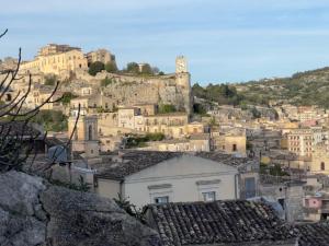a view of a city with a clock tower on a hill at CasaCastellett in Modica