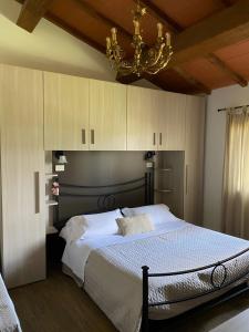 a bedroom with a large bed with a chandelier at Agriturismo La Luciana in Castiglione della Pescaia