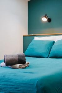 a blue bed with a towel on top of it at Le bijou des carmes - Haut de gamme climatisé in Toulouse