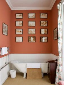 a bath tub in a bathroom with orange walls at Torloisk House in Kilninian +41 photos