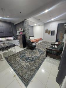 een woonkamer met een keuken en een woonkamer met een tapijt bij Kesuma Homestay Pantai Murni in Yan