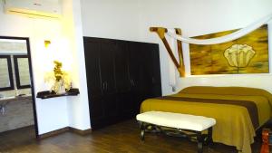 sypialnia z łóżkiem z żółtym kocem w obiekcie Sunset w mieście El Desengaño