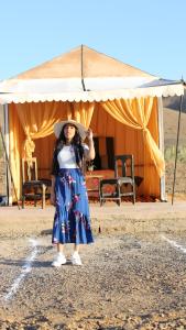 a woman wearing a hat standing in front of a tent at la casa de othmane in Marrakesh