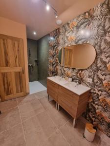 ein Badezimmer mit einem Waschbecken und einem Spiegel an der Wand in der Unterkunft Le Mas des Cigales in Saumane-de-Vaucluse