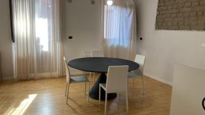 a dining room with a black table and chairs at La Suite Sotto Stelle in Oristano