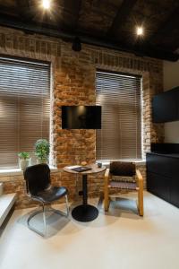- un salon avec un mur en briques, une table et des chaises dans l'établissement Hortus Vilnius, à Vilnius
